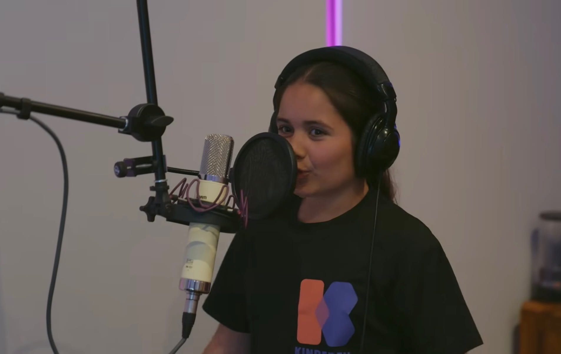 Marisa in de studio met koptelefoon achter de microfoon