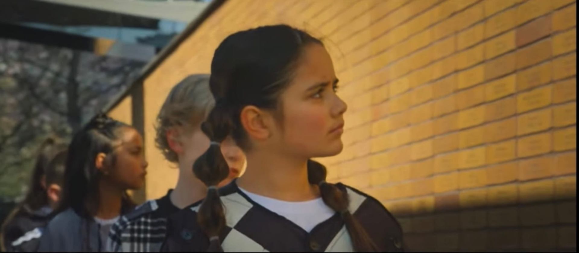 Marisa in beeld tijdens de videoclip-opnames met vlechtjes en geblokt vest